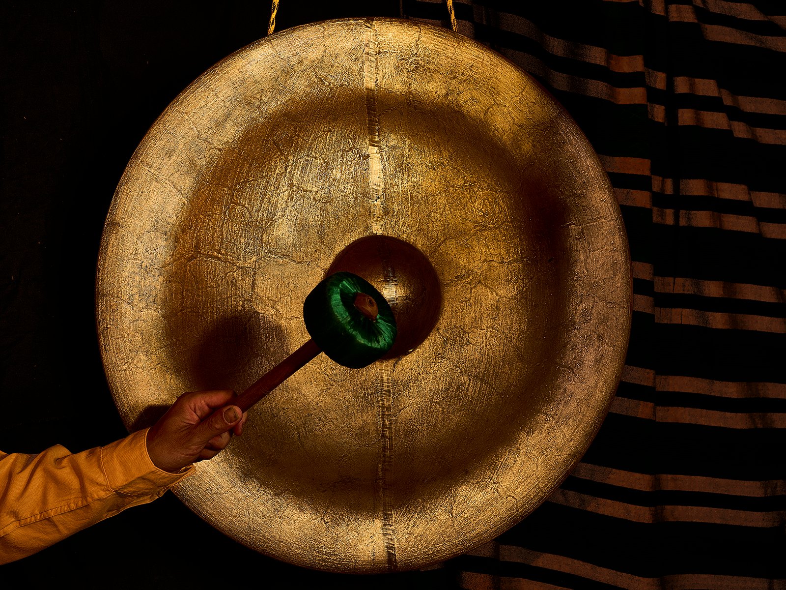 Close-up of a bronze gong surface catching warm light