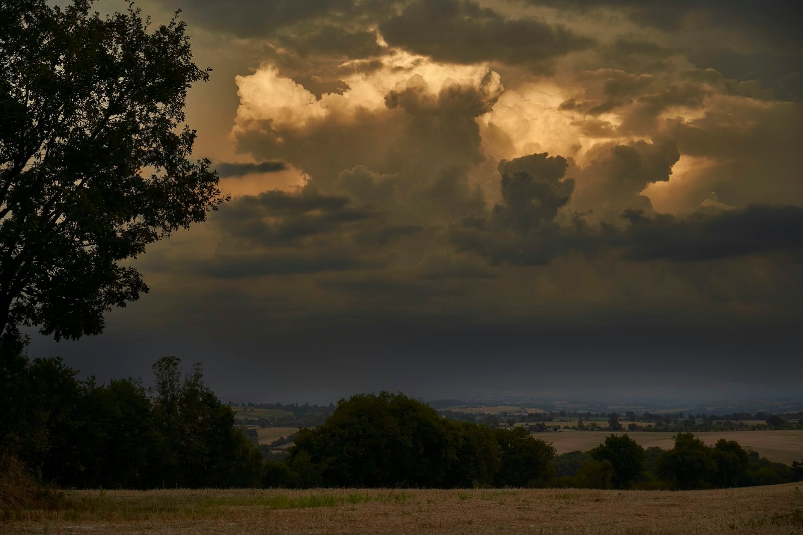 Storm clouds lit with gold over the countryside